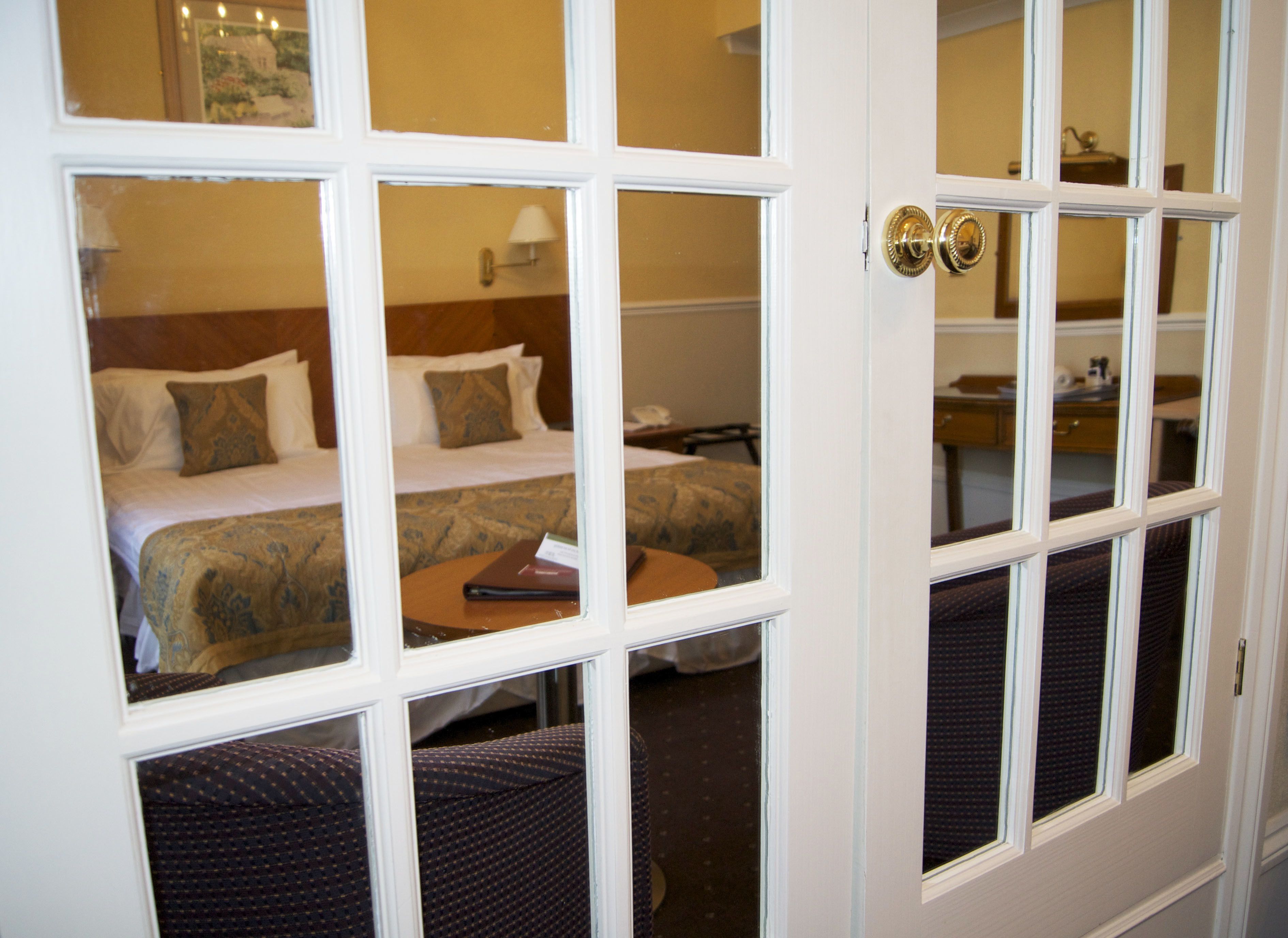 A hotel room with two beds, a small table, and a chair.