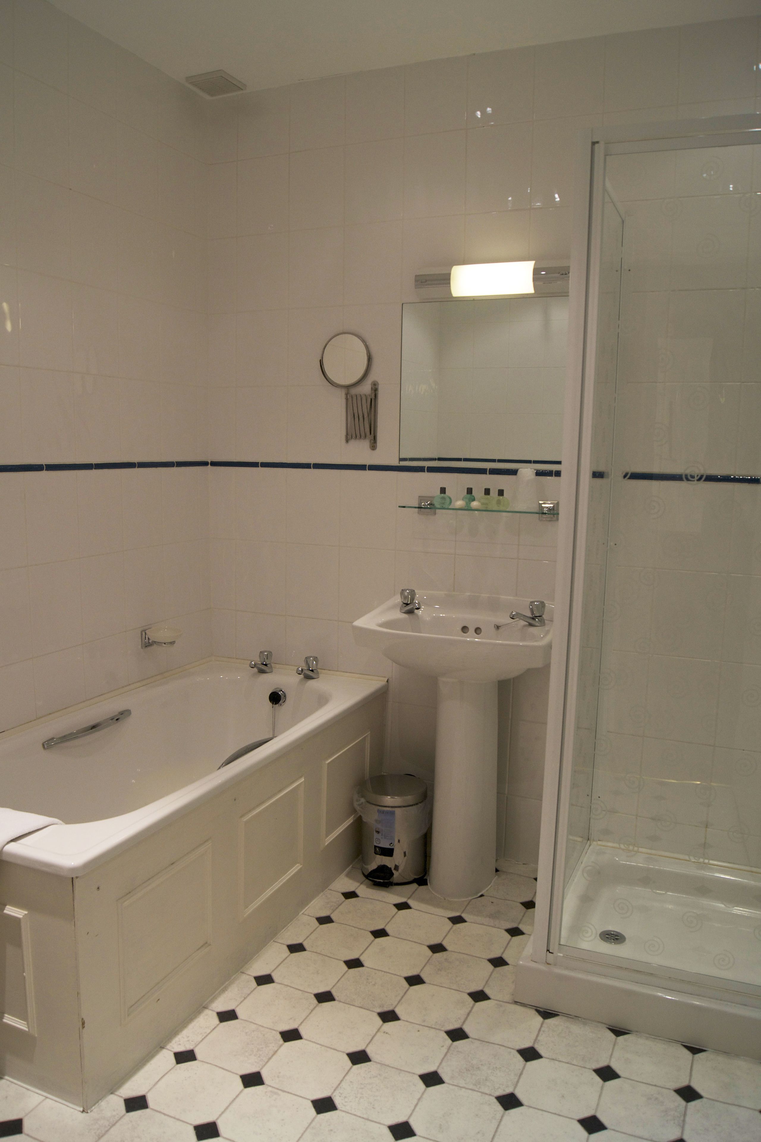 A bathroom with a bathtub, sink, and shower.