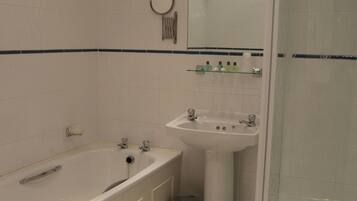 Un baño con bañera, lavabo y ducha.