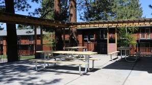 An outdoor patio area with picnic tables and a covered seating area. - Bluelake Inn at Tahoe (South Lake Tahoe)