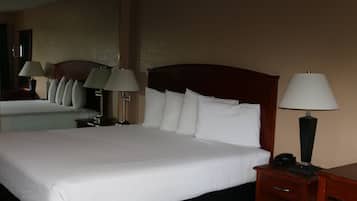 A hotel room with a large bed, two bedside tables, and two lamps.
