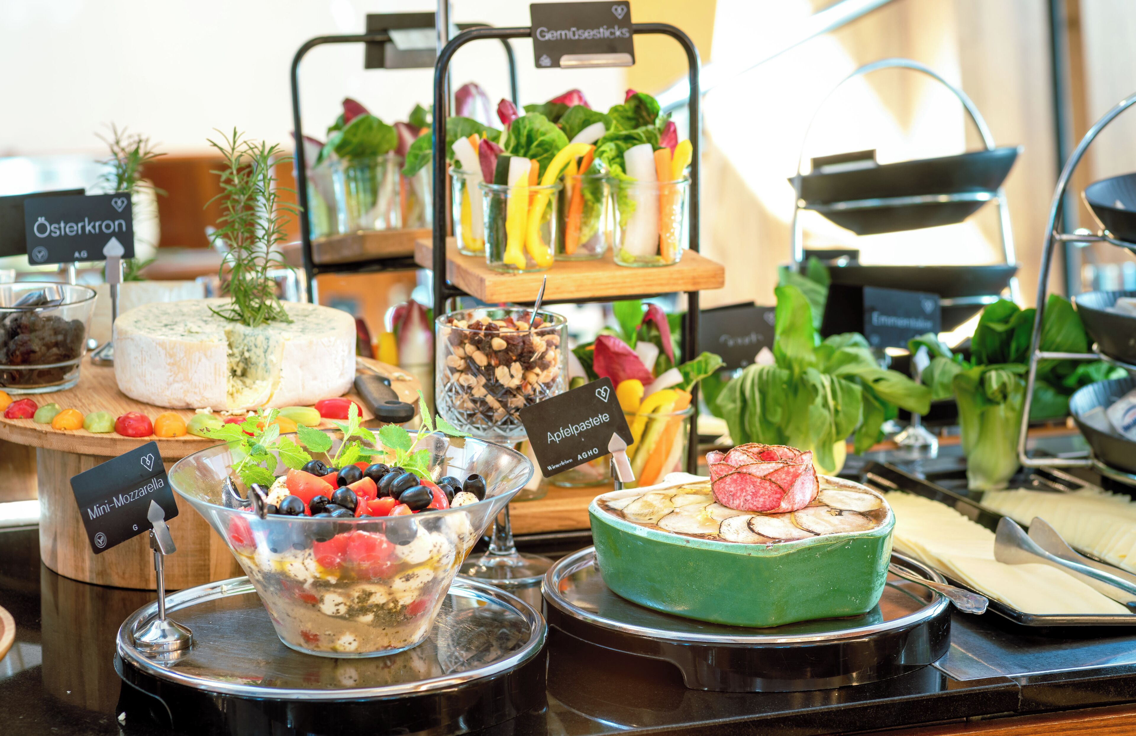 A buffet with various food items including cheese, fruits, and salads.