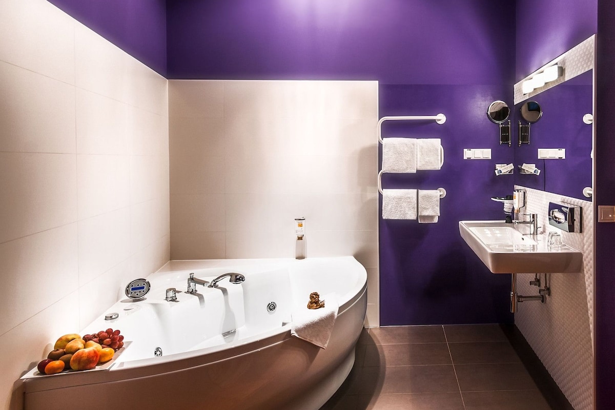 A modern bathroom with a freestanding bathtub, a vanity with a mirror, and a towel rack.