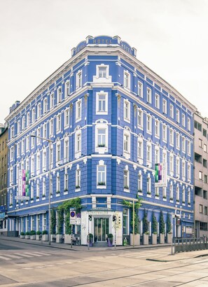 Un edificio azul en esquina con un cartel que dice "HOTEL DONAUWAIZER".