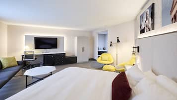 Relax in a spacious room with a large bed, flat-screen TV, and comfortable seating area.