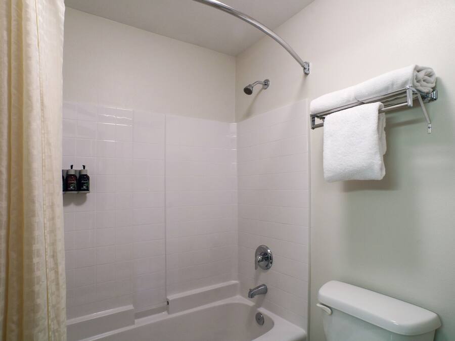 Un bagno con vasca, water e porta asciugamani.