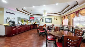 Un restaurante con una zona central de comedor, una cocina y un bar.