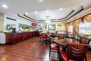 A restaurant with a central dining area, a kitchen, and a bar.