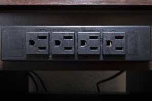 A power strip with four sockets, a caution label, and a note for indoor use only. - Red Roof Inn Atlanta Southeast - Stockbridge (Stockbridge)