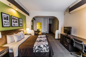 A hotel room with a bed, a desk, a TV, and a bathroom visible through an archway. - Sleep Inn & Suites Orlando International Airport (Orlando)