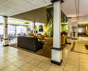 A spacious lobby with a reception desk, comfortable seating, and a view of the outdoors.