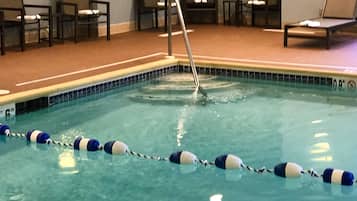 En swimmingpool med linedelere, liggestole og en poolstige.