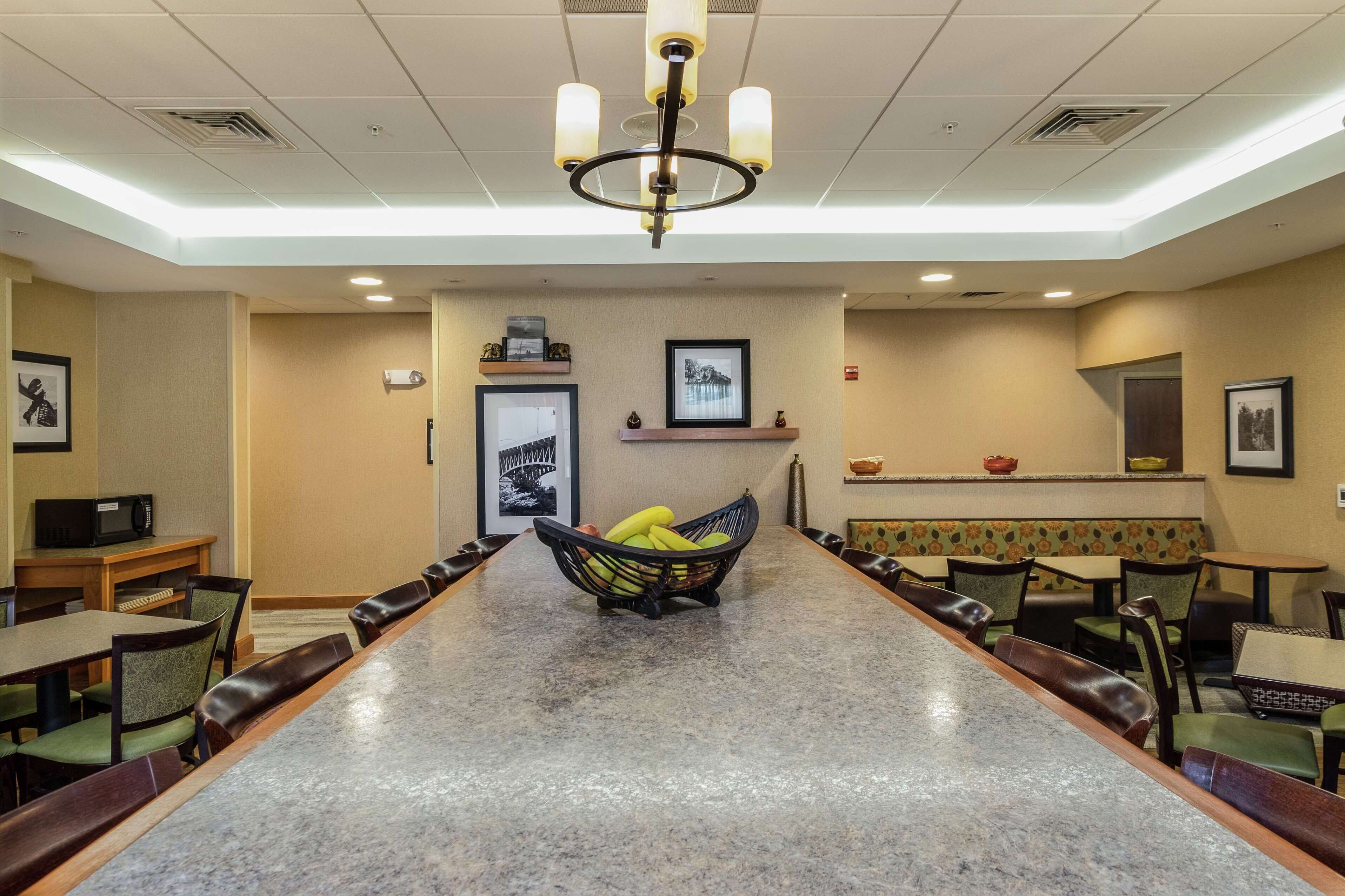 A conference room with a long table, chairs, a fruit basket, and a chandelier.