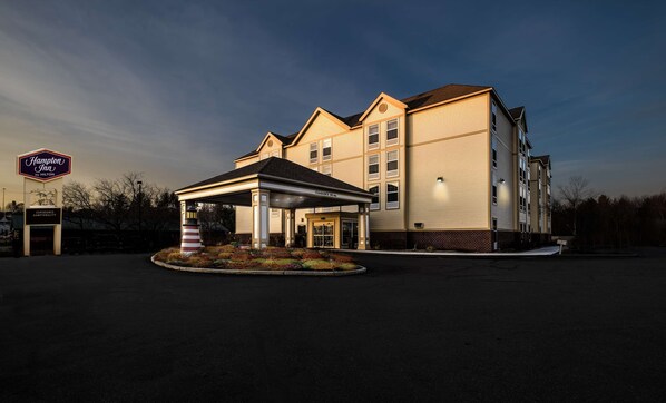 A Hampton Inn by Hilton hotel with a covered entrance, a lighthouse feature, and a landscaped area.