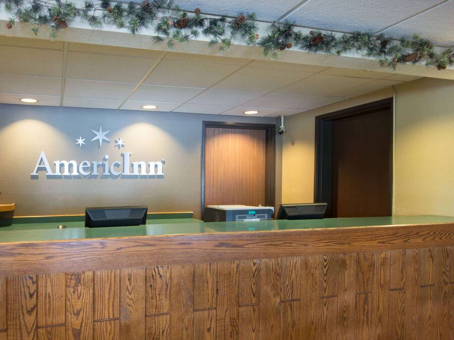 A reception desk with a wooden finish and a sign that reads "AmerInn".