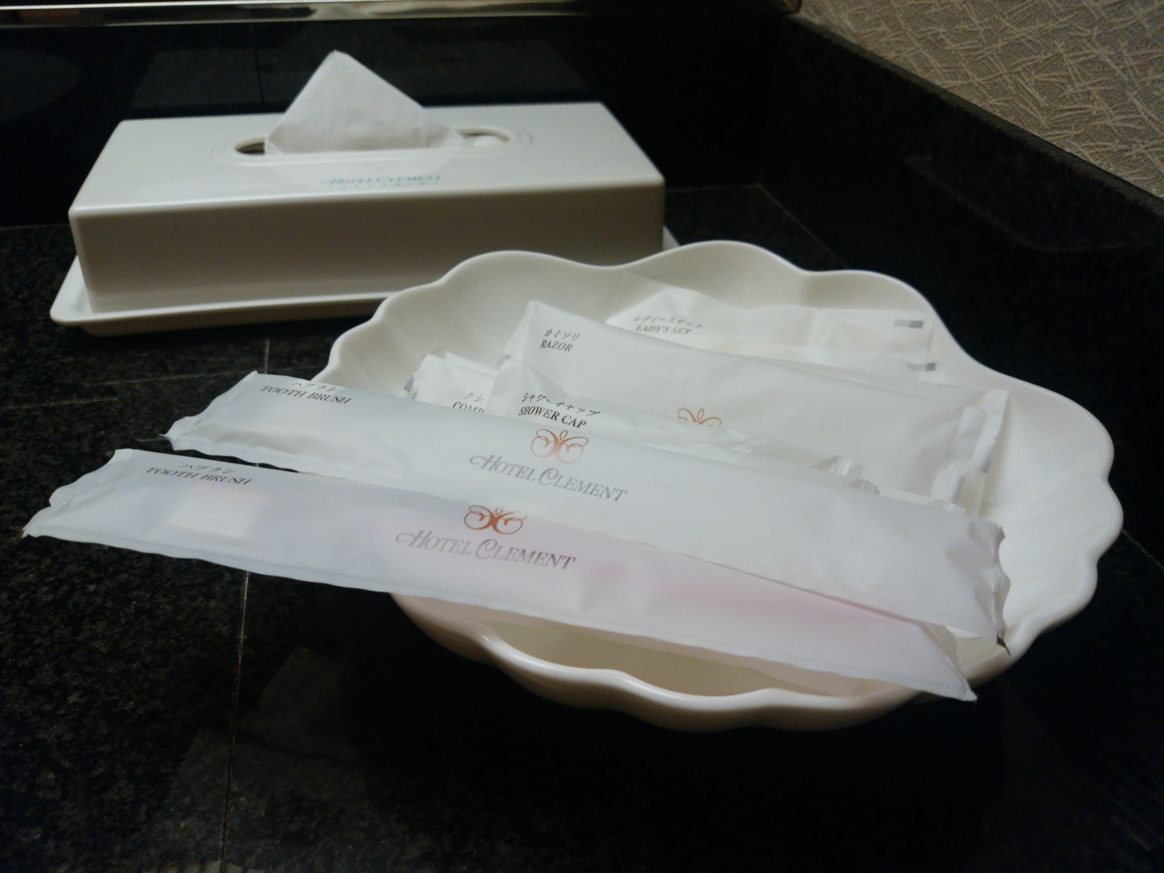 A hotel amenities tray with a tissue box and toiletries.