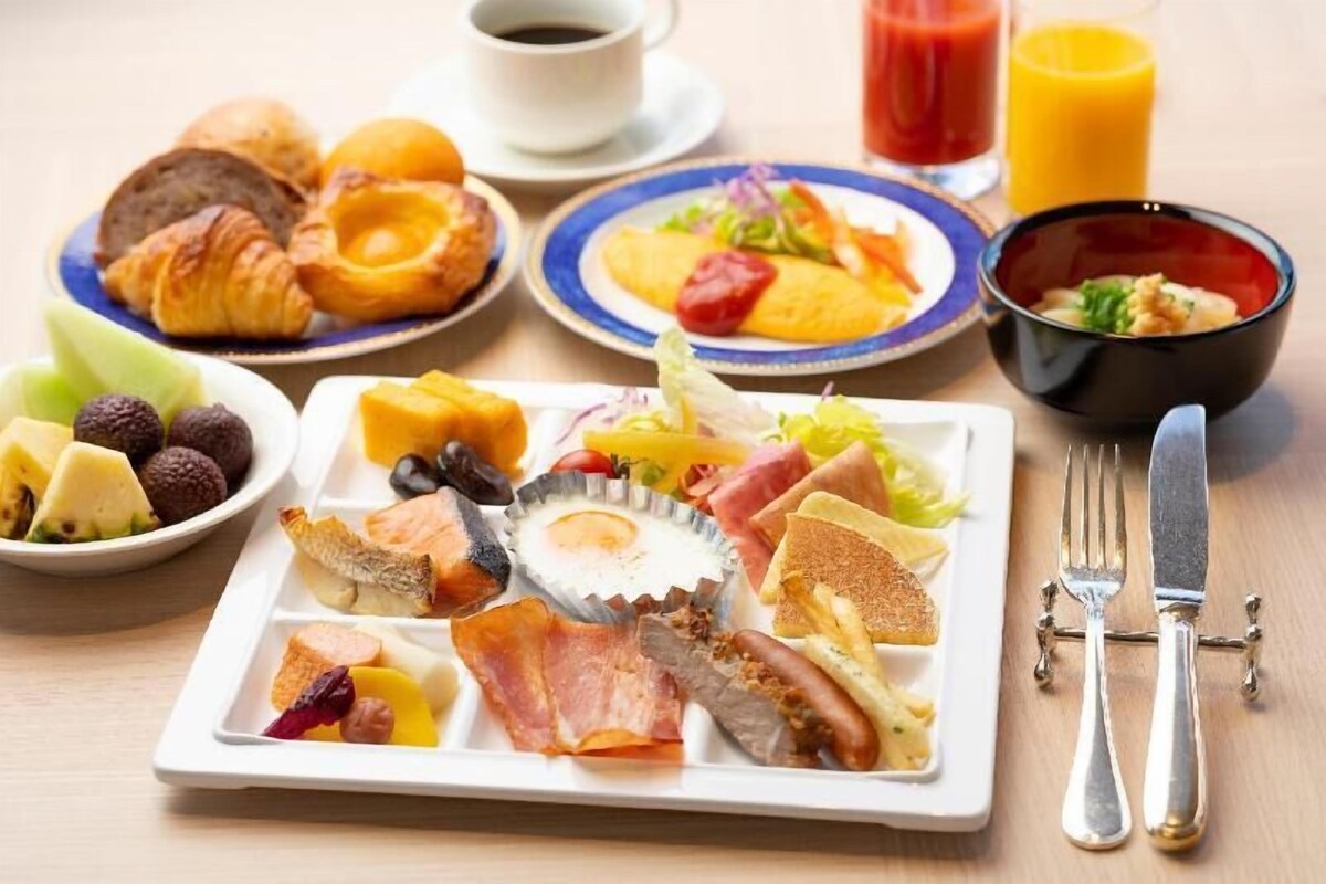 A breakfast buffet with various food items, a cup of coffee, and a glass of orange juice.
