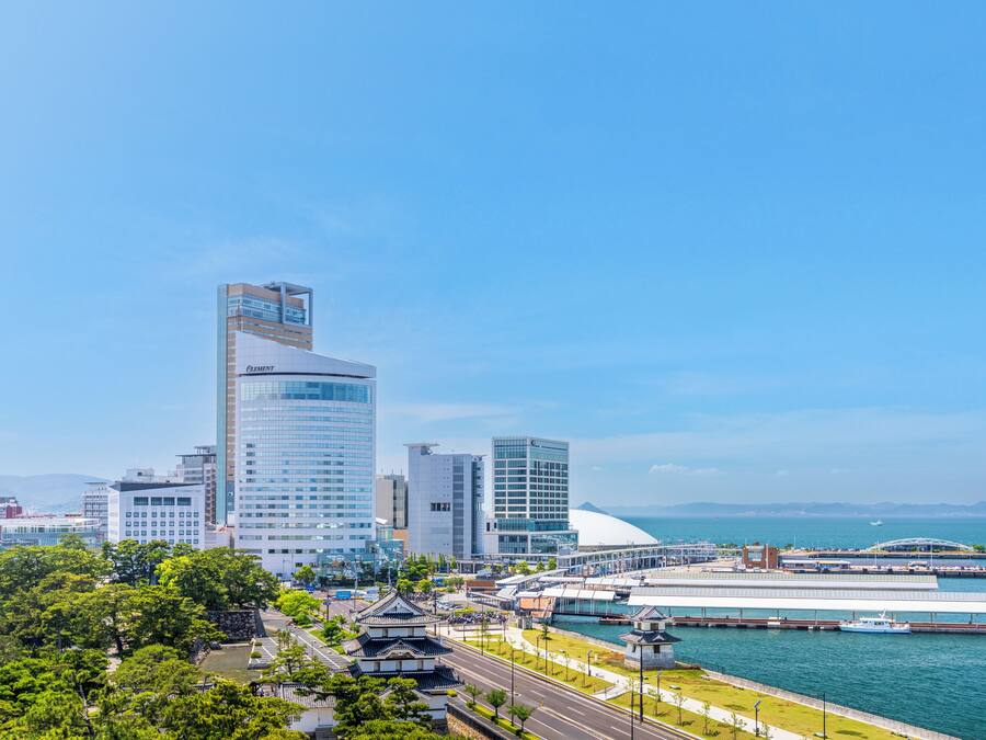 A cityscape with modern buildings, a waterfront, and a traditional pagoda.