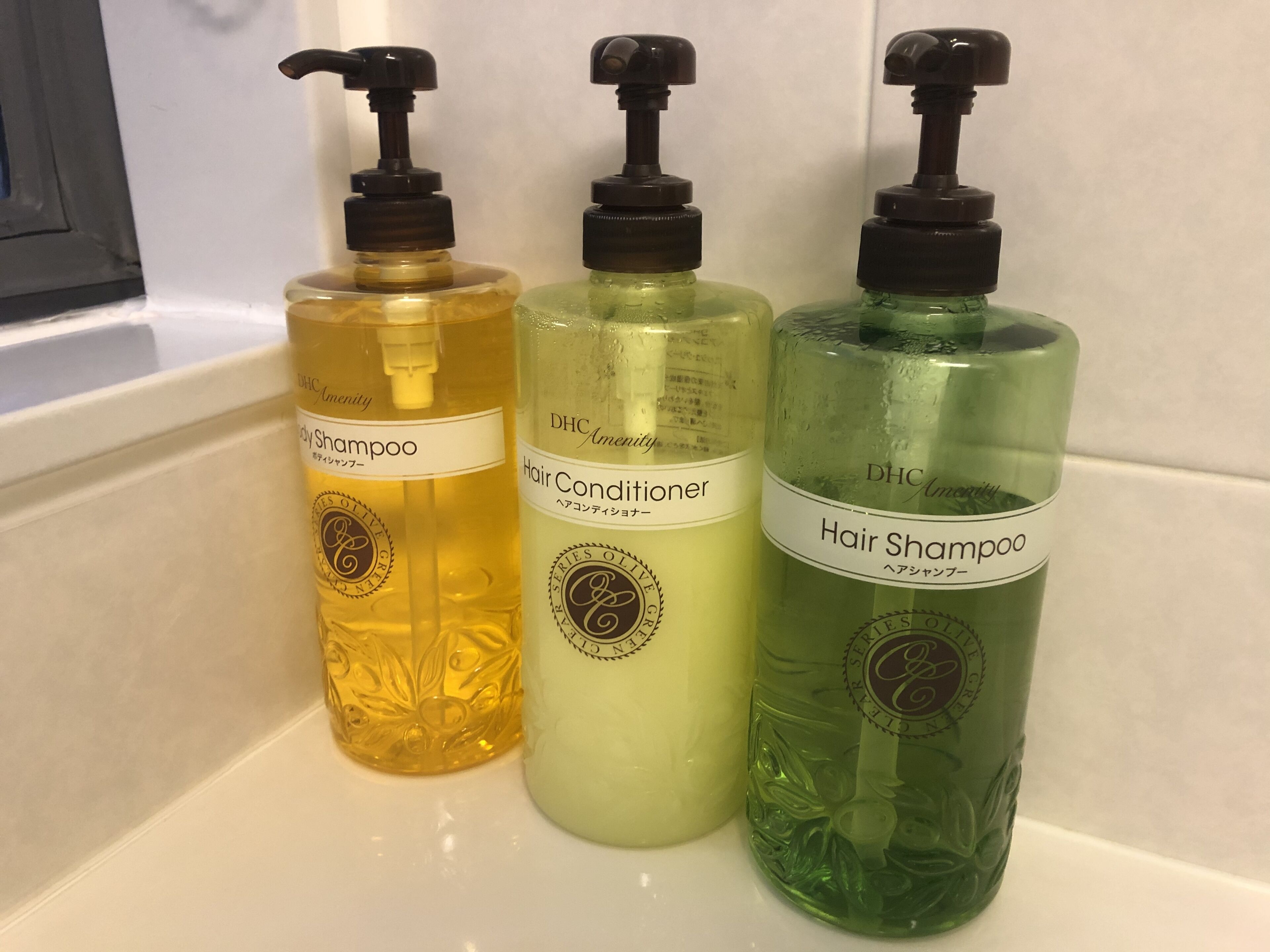 Drei Flaschen Haarpflegeprodukte auf einer weißen Fläche.
