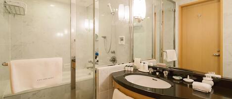 A modern bathroom with a glass-enclosed shower, a large mirror, and a black countertop with a sink.