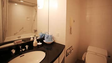 A bathroom with a sink, mirror, shower, and toilet.
