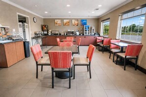 A restaurant with a counter, seating, and kitchen area. - Comfort Inn Columbia Gorge (The Dalles)