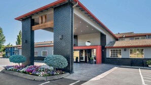 A modern building with a brick facade, a red roof, and a covered entrance area. - Comfort Inn Columbia Gorge (The Dalles)