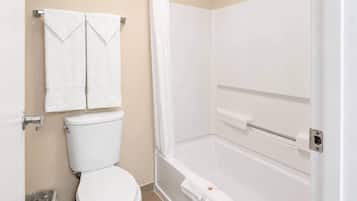 A bathroom with a toilet, a shower, and two towels hanging on the wall.