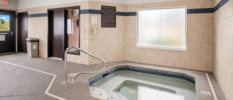 A spa area with a hot tub, a trash bin, and a sign indicating spa use.