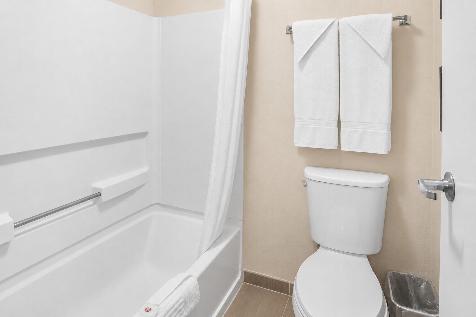 A bathroom with a bathtub, toilet, and a shower curtain.