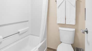 A bathroom with a bathtub, toilet, and a shower curtain.