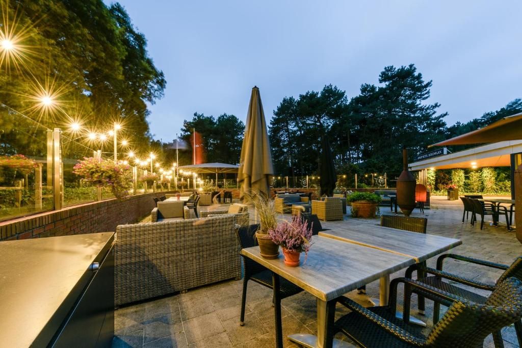 An outdoor patio area with seating arrangements, a table, and a decorative umbrella.