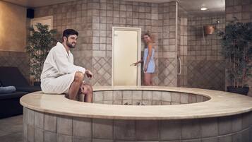 Relax in a tranquil spa area with a central hot tub and rooms.