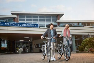 Un edificio moderno con un letrero que dice 'APARTHOTEL BOSCHRIJK'.