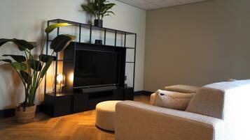 Kamer (Suite Apartment, Fully renovated) | Woonruimte | Een 50-inch smart-tv met satellietzenders en een televisie