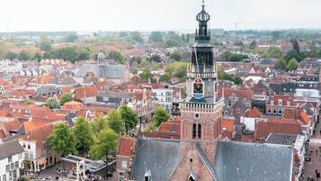 A historic town with a prominent clock tower, a canal, and a pedestrian area with outdoor seating.