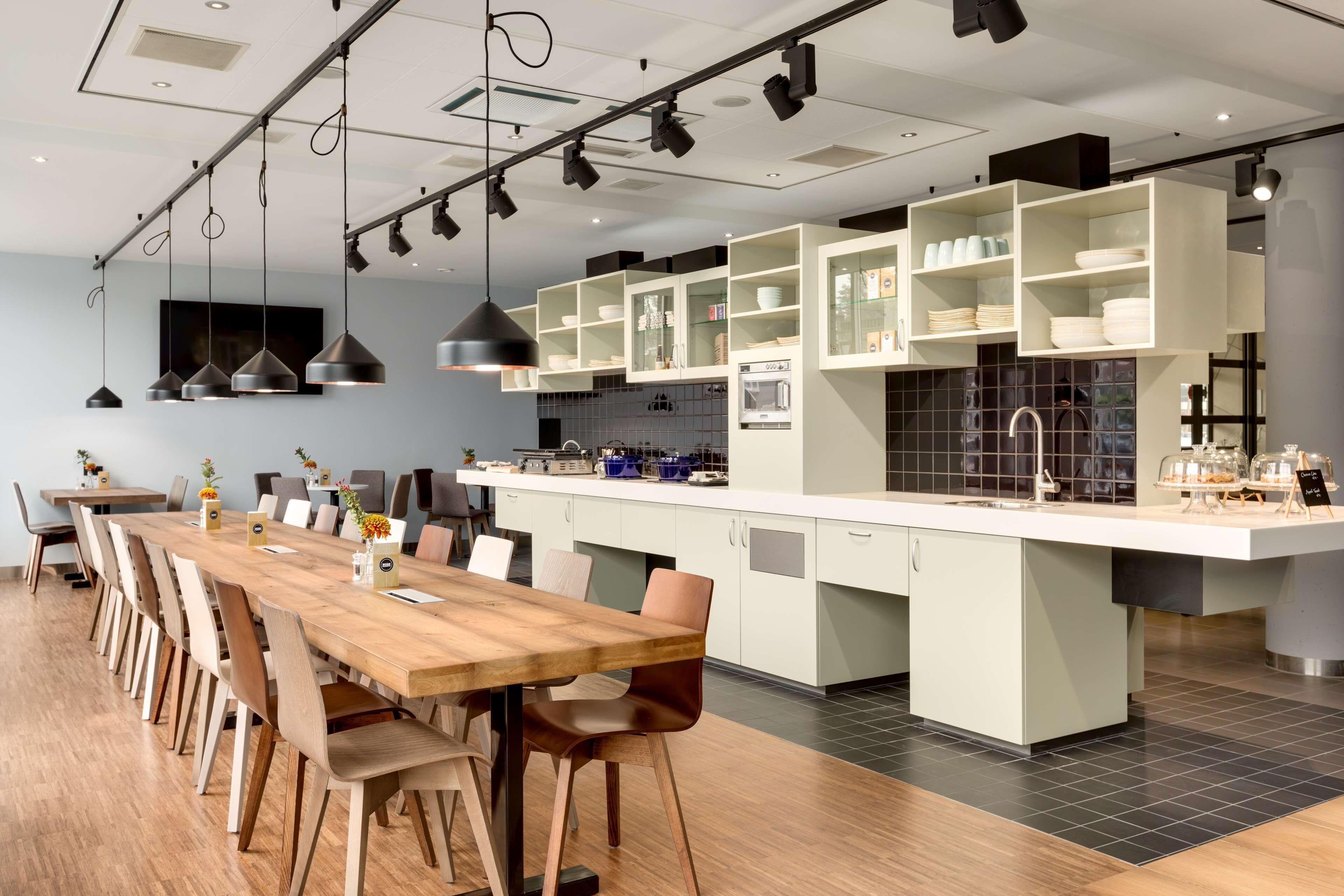 Una cucina moderna con isola centrale, tavolo da pranzo in legno e sedie.