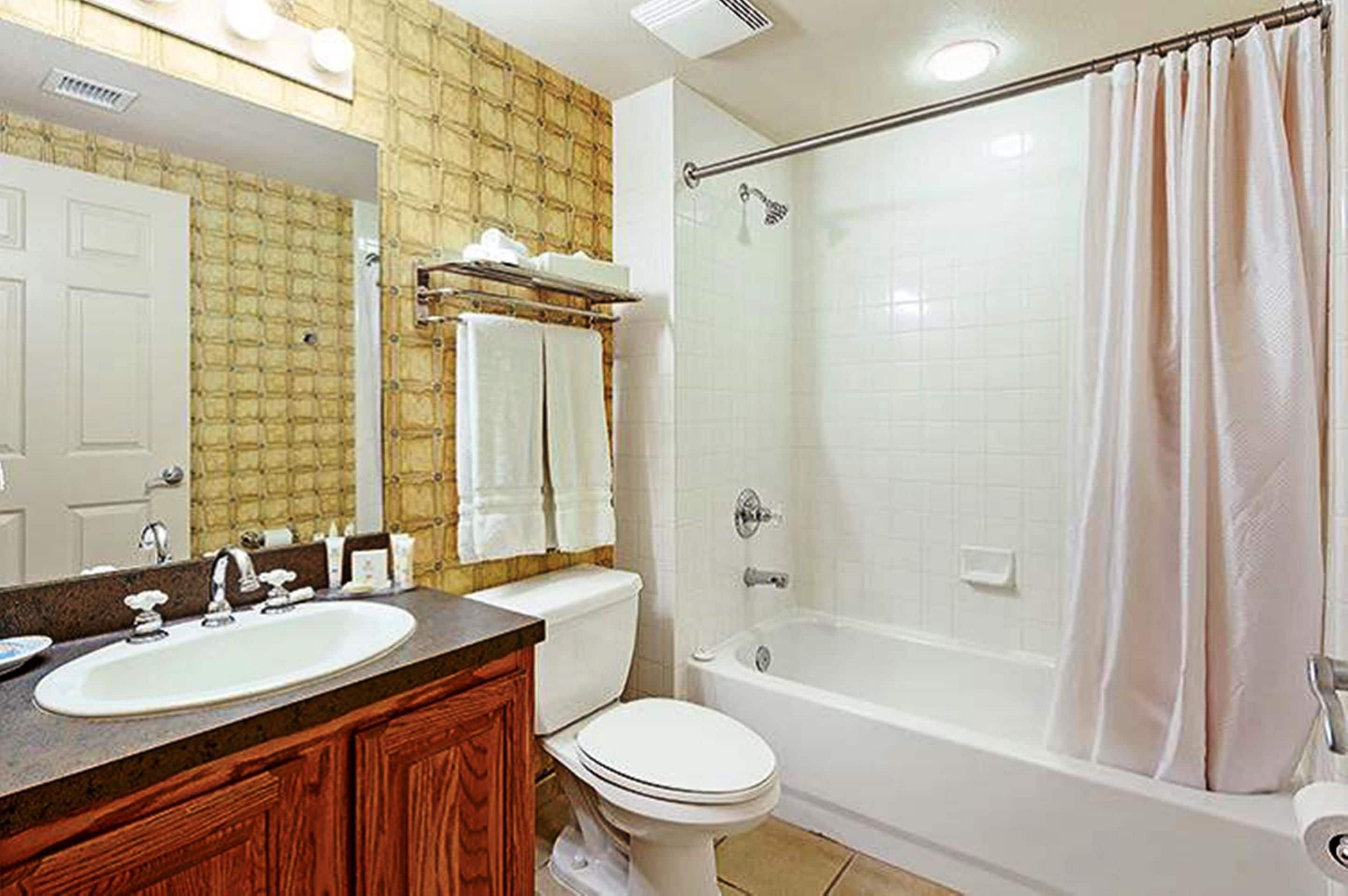 Une salle de bain avec un lavabo, des toilettes et une baignoire.