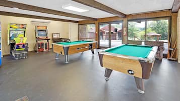 Eine Poolbar mit zwei Billardtischen, Spielautomaten und Blick ins Freie.