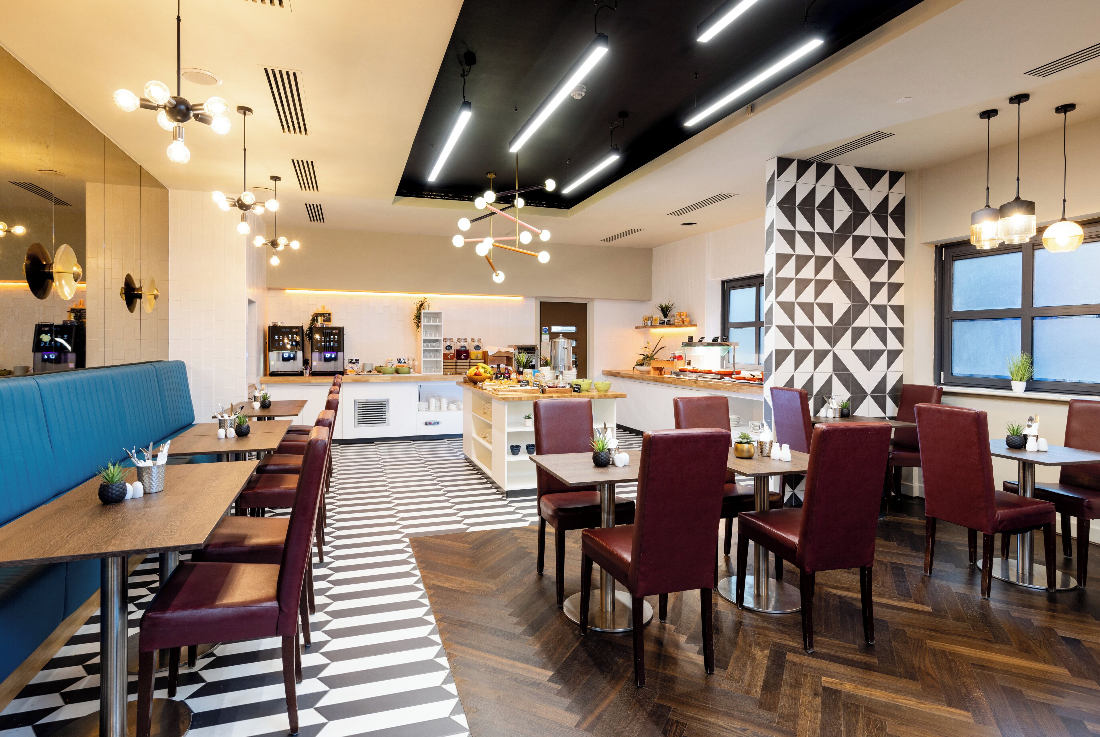 Un restaurante moderno con una larga mesa común, mesas individuales y diversas opciones de asientos.