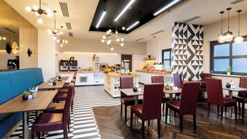 Un restaurante moderno con una larga mesa común, mesas individuales y diversas opciones de asientos.