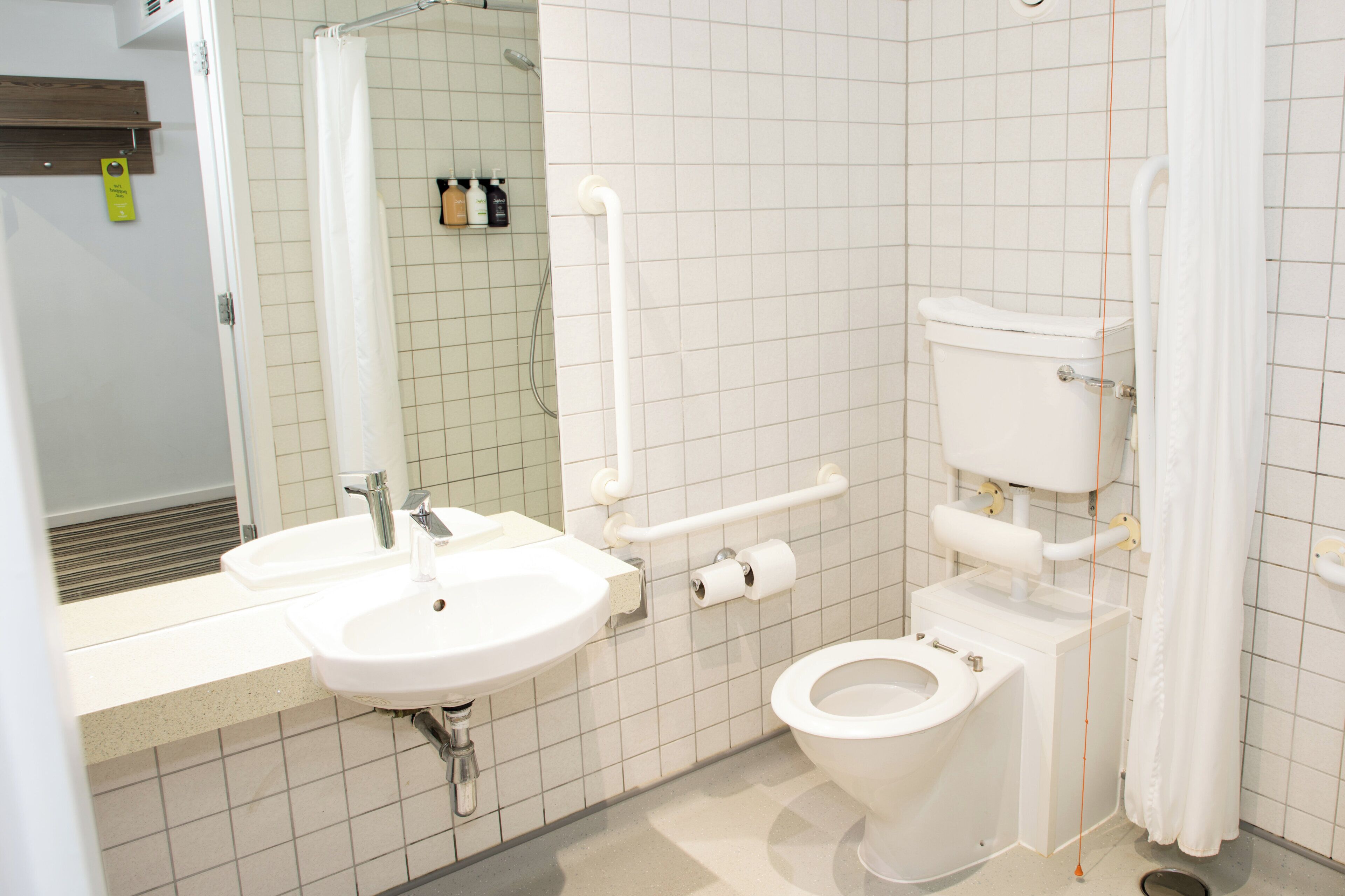 Une salle de bain avec un lavabo, des toilettes et un miroir.