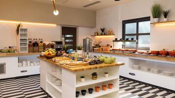 Una cocina moderna con una isla central, diversos alimentos y un piso con estampado de cuadros.