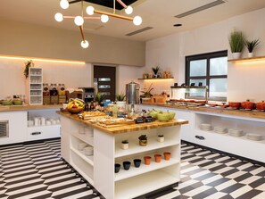 A modern kitchen with a central island, various food items, and a checkered floor pattern. - Holiday Inn York City Centre by IHG (York)