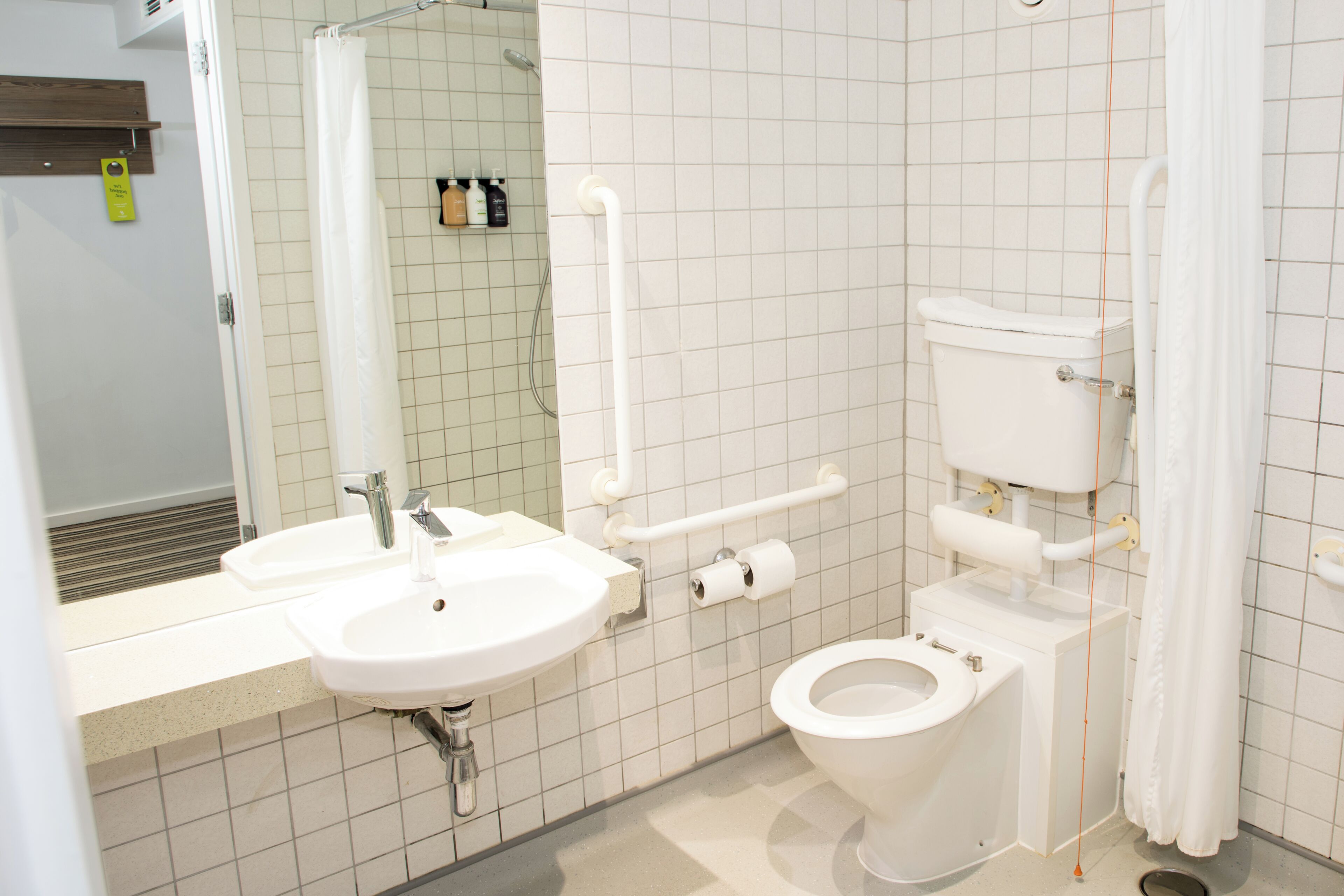 Une salle de bain avec un lavabo, des toilettes et un miroir.