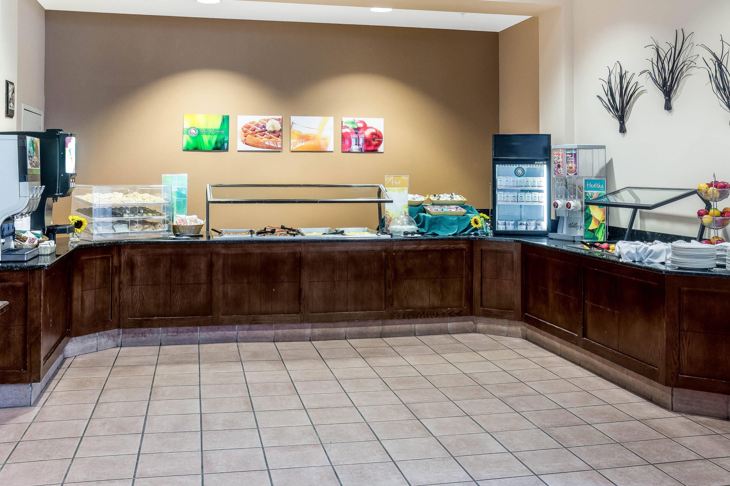 A breakfast buffet area with various food items and a coffee machine.