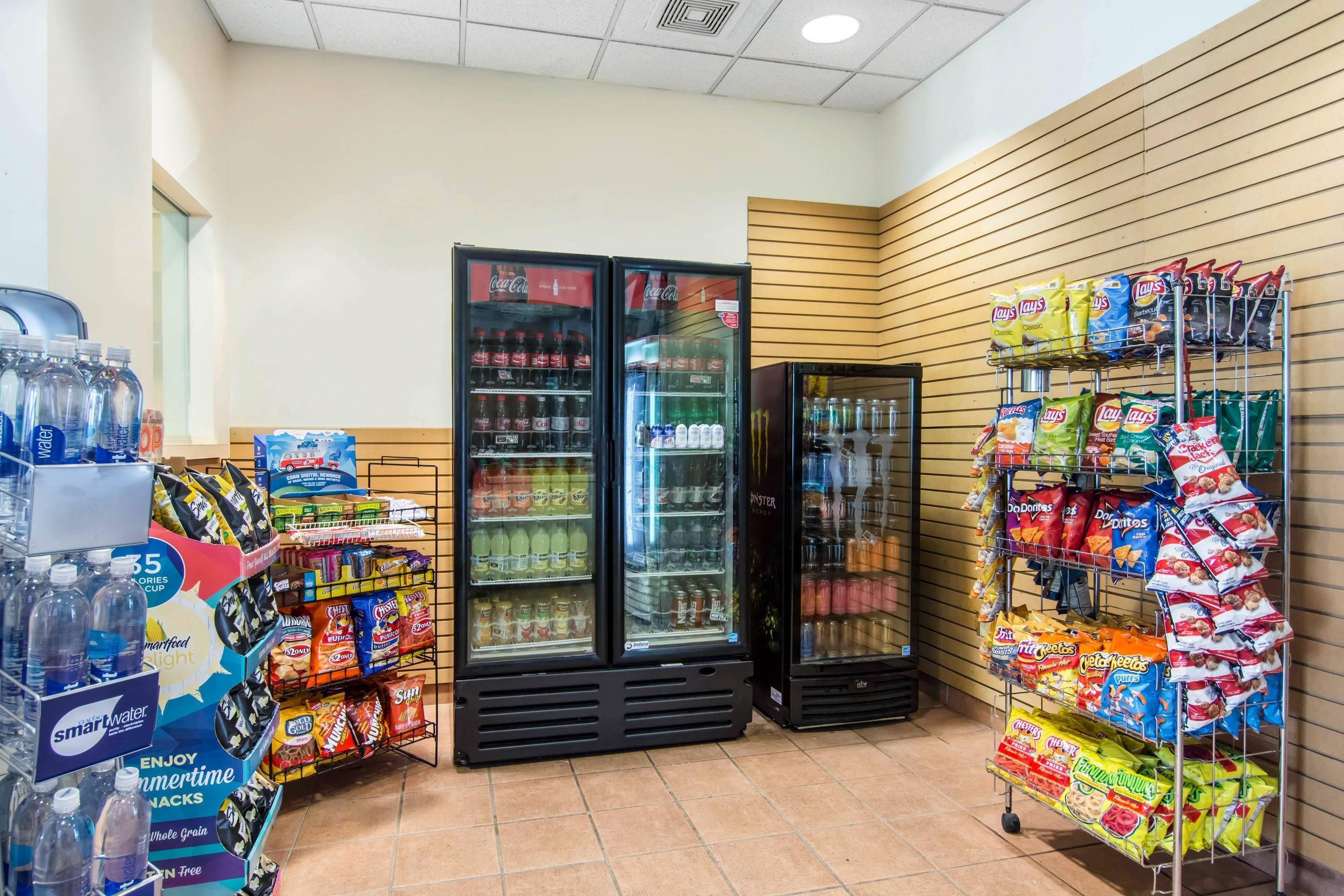 Een afdeling met snacks en drankjes, inclusief gekoelde dranken, zakjes snacks en flessenwater.