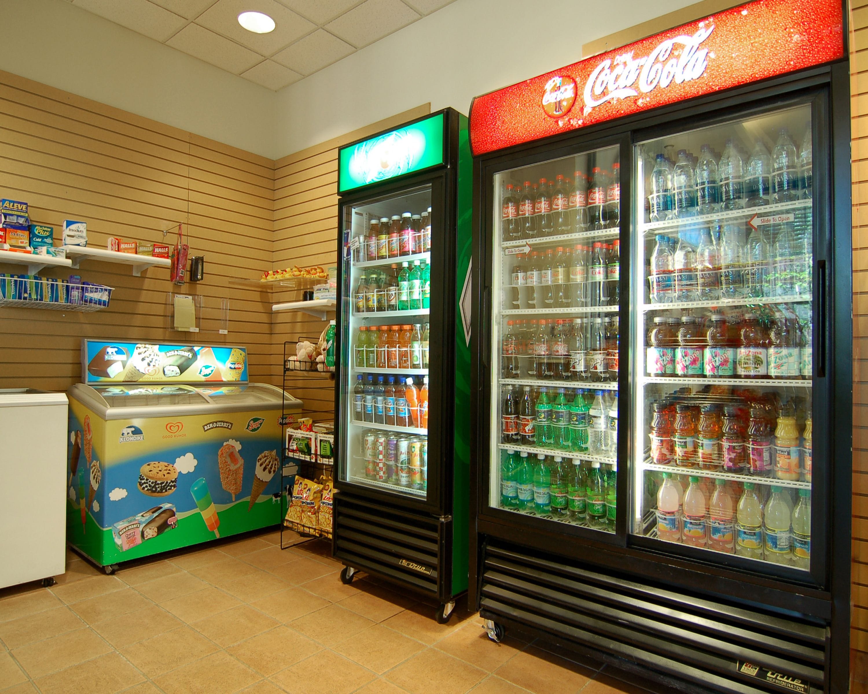Un espace de vente proposant des distributeurs de crème glacée et de boissons gazeuses, ainsi que des étagères remplies d’en-cas et de boissons.