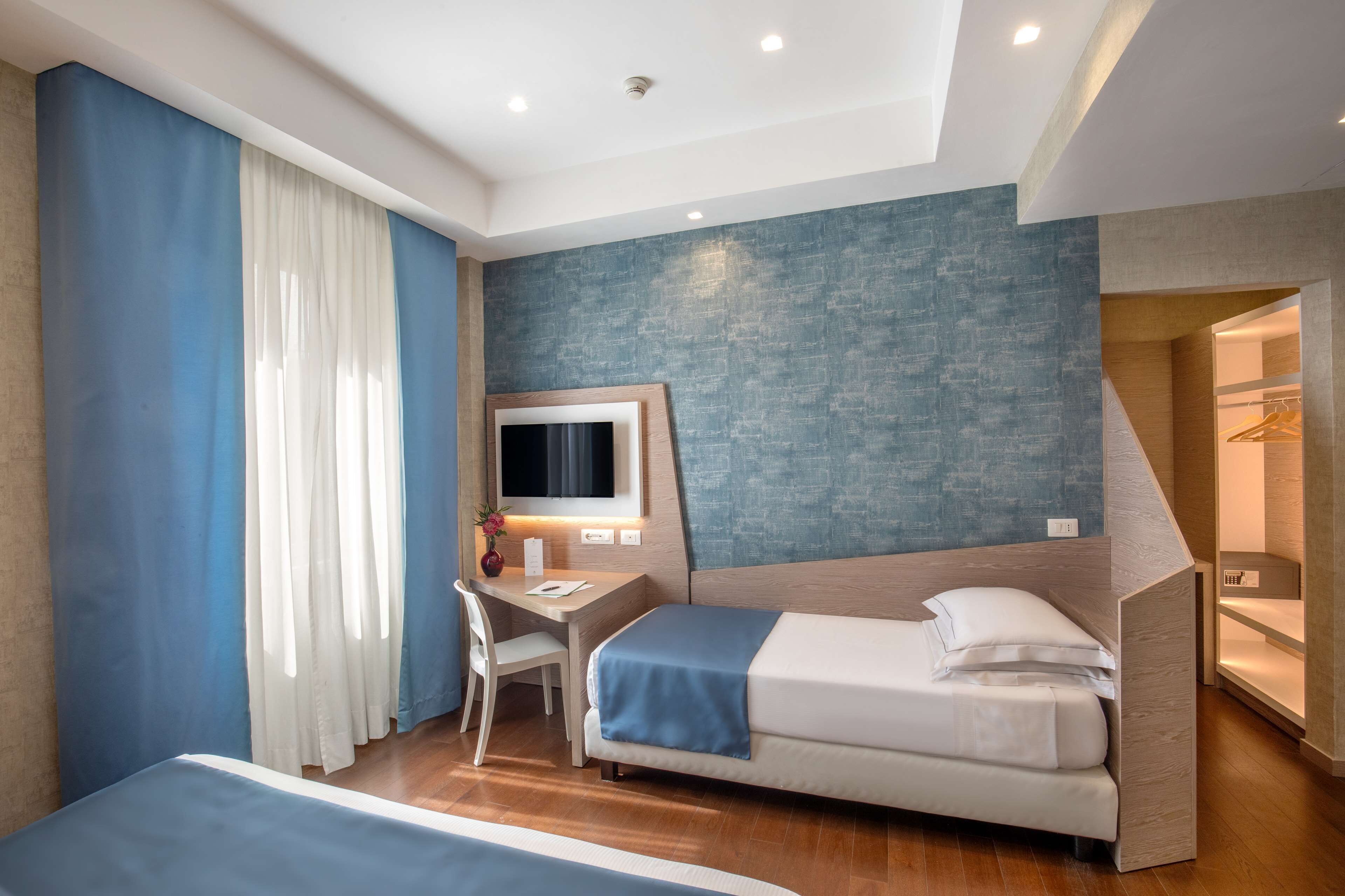Una habitación de hotel moderna con cama, escritorio y silla.