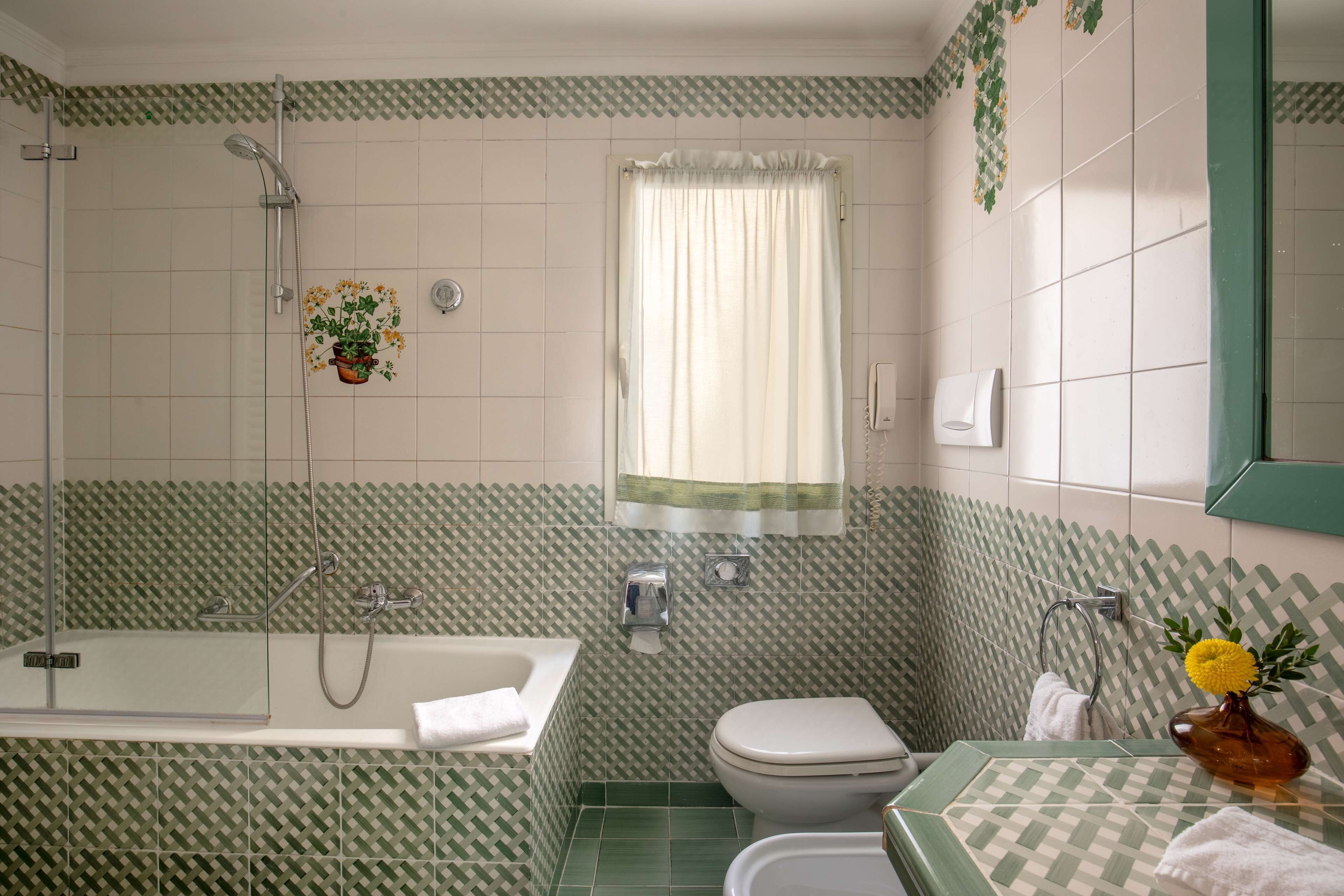 A bathroom with a shower, toilet, and sink.